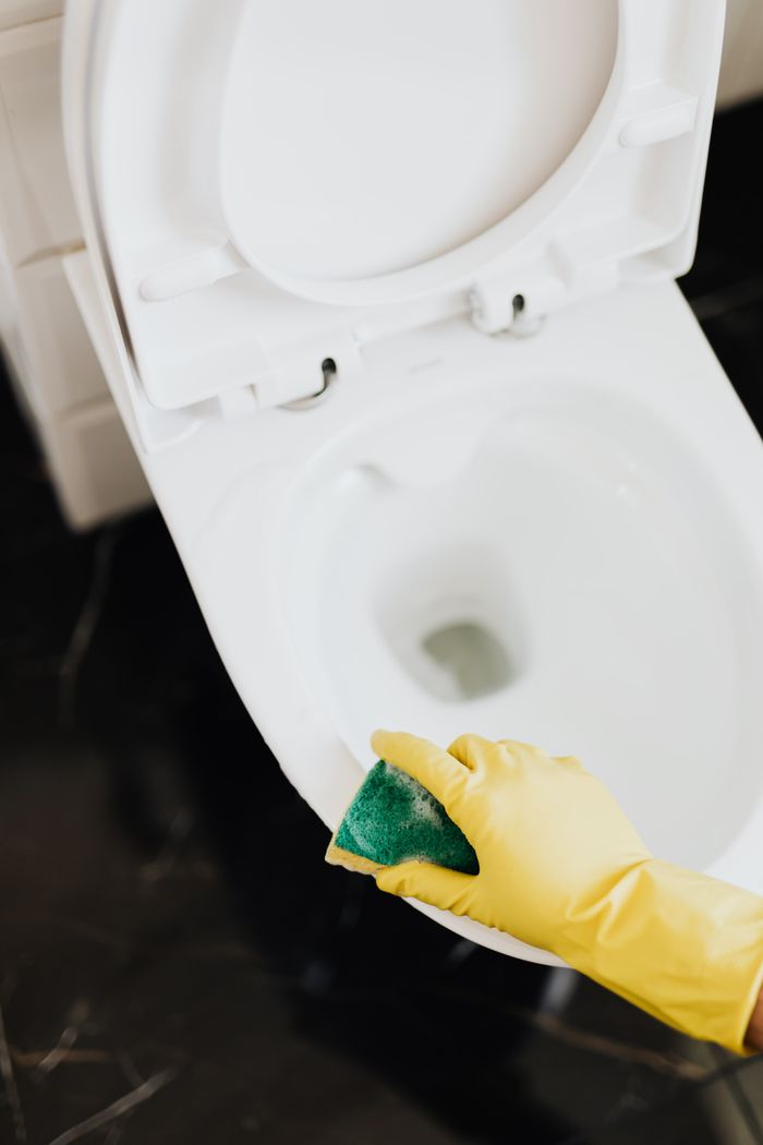 extra-programs-img From above crop unrecognizable cleaner in rubber yellow gloves using sponge to wipe off toilet bowl in restroom
