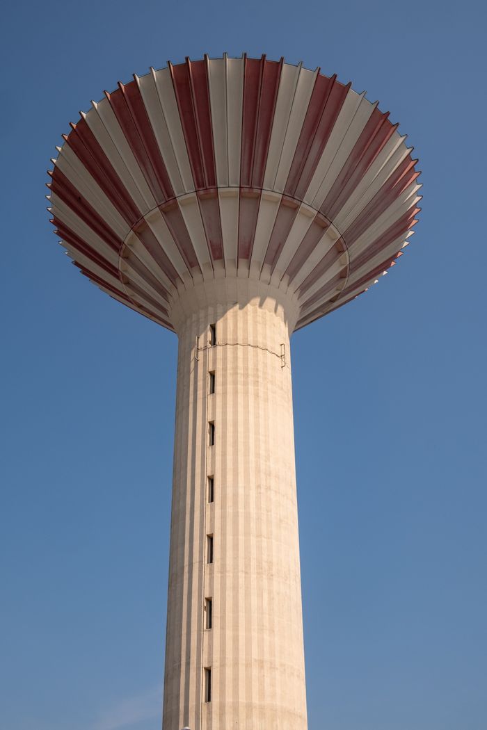 A striking view of the Csepel Water Tower in Budapest, Hungary with a clear blue sky backdrop.
